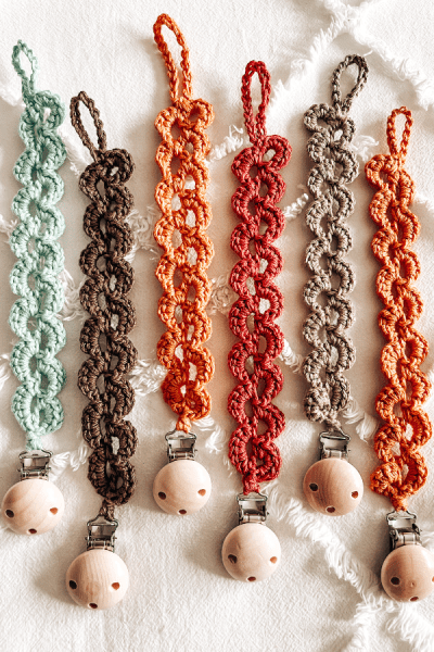 An image of 6 crochet pacifier clips in different colours.