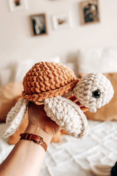 An image of a sea turtle made out of crochet, mustard colour.
