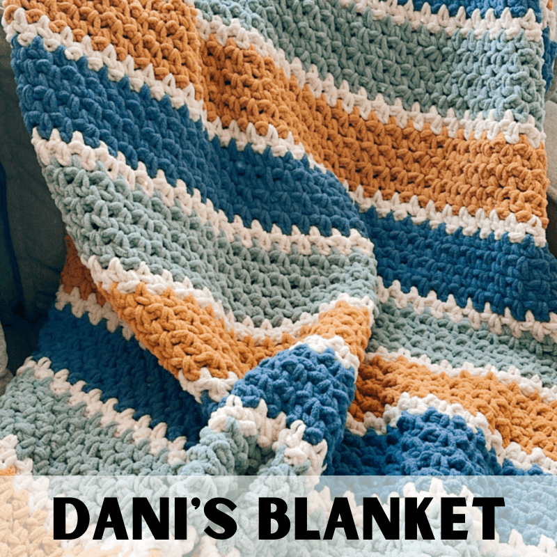 a handmade crochet blanket with stripes on a couch